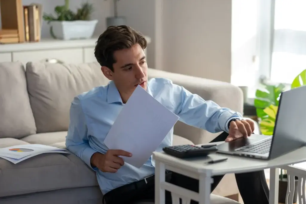 Homebuyer reviewing tax returns and bank statements at a laptop