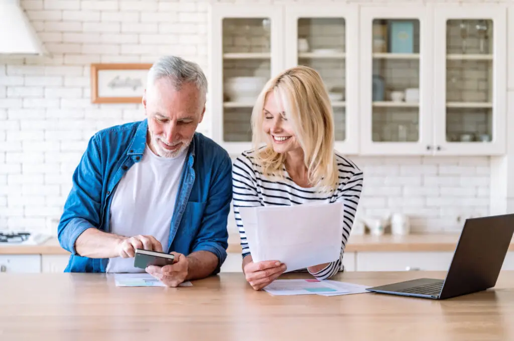 Retired couple reviewing their home purchase plans together at the kitchen counter